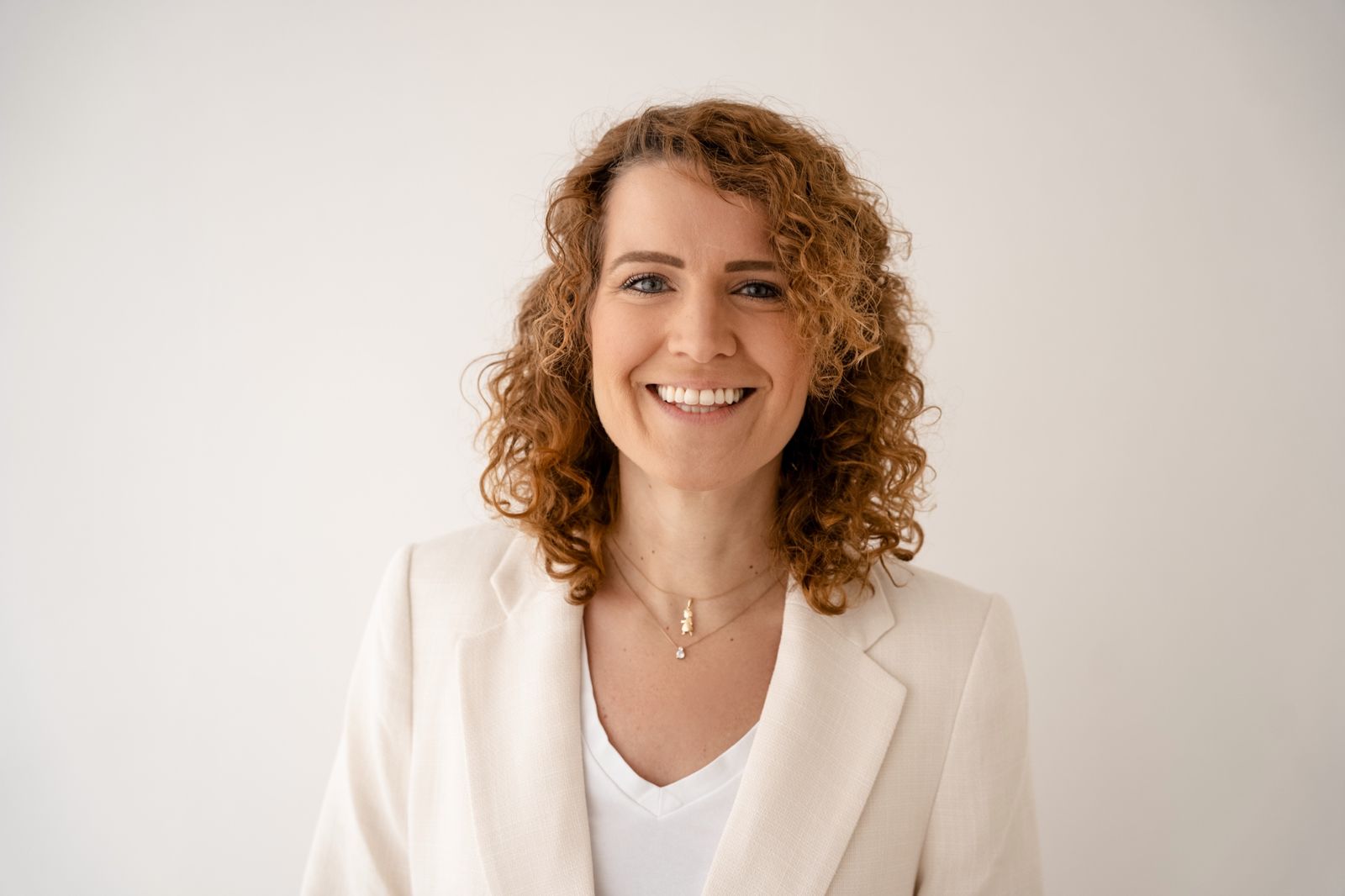 Annika Schmitz, Hypnose-Coachin, im hellen Blazer vor heller Wand